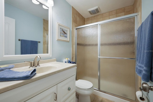 bathroom with toilet, a shower with door, tile flooring, and vanity