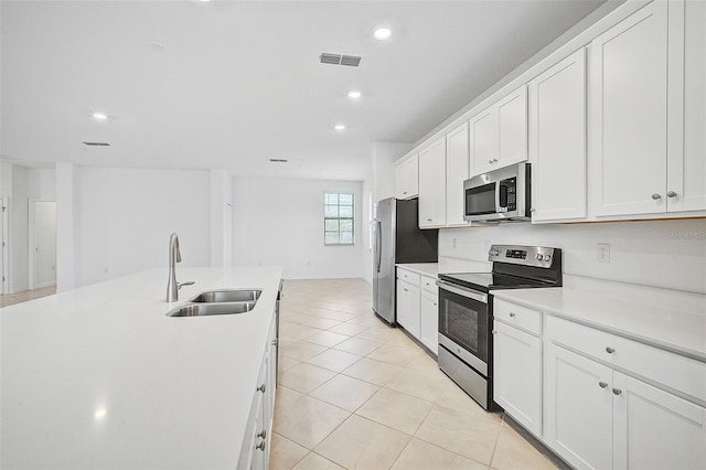 kitchen with light tile patterned flooring, white cabinetry, sink, and appliances with stainless steel finishes