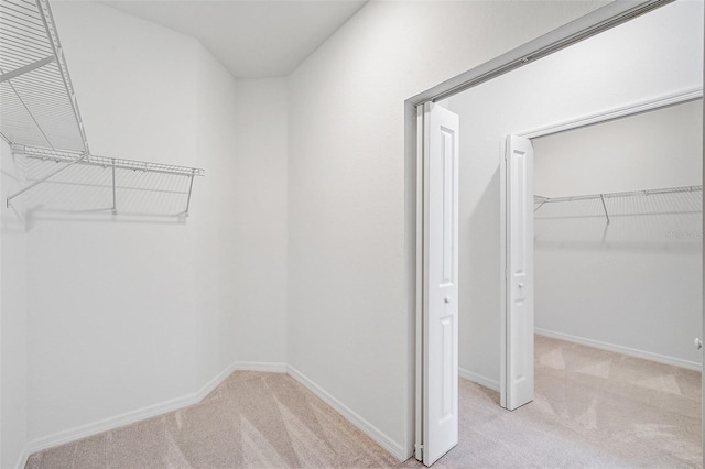 walk in closet featuring light carpet