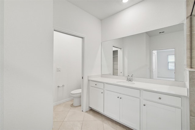 bathroom with tile patterned flooring, vanity, and toilet