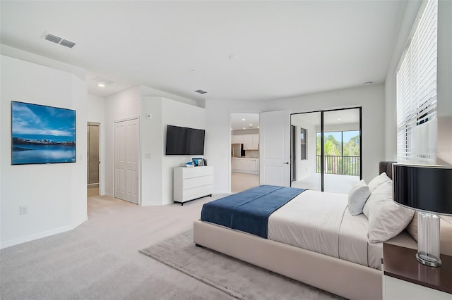 bedroom featuring light carpet, access to outside, and two closets