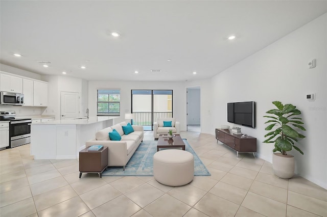 living room featuring sink and light tile patterned floors