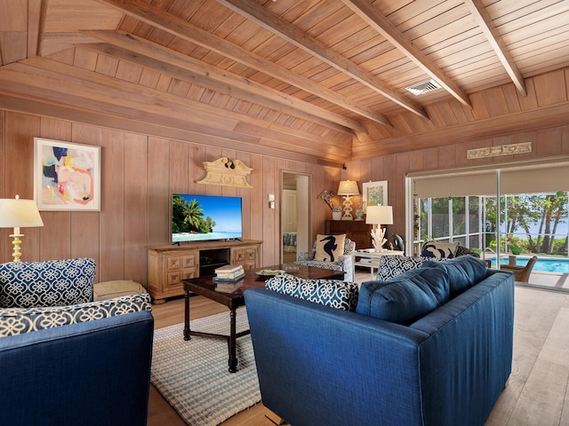 living room featuring vaulted ceiling with beams, light hardwood / wood-style flooring, wood walls, and wood ceiling