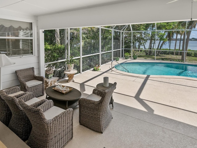 view of pool with a patio, a water view, and a lanai