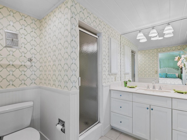 bathroom with vanity, toilet, and a shower with door