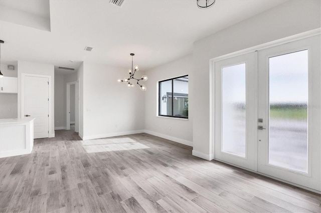 interior space with light wood-type flooring, baseboards, visible vents, and french doors