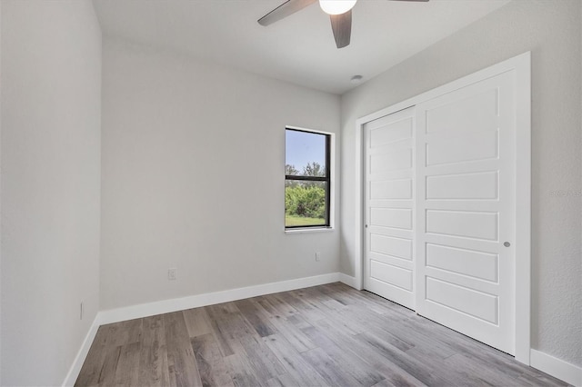 unfurnished bedroom with light wood-type flooring, ceiling fan, baseboards, and a closet