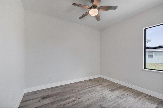 spare room featuring light hardwood / wood-style floors, ceiling fan, and a healthy amount of sunlight