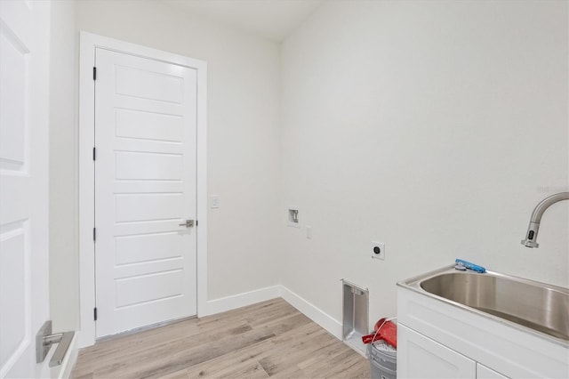 clothes washing area featuring hookup for an electric dryer, cabinets, sink, and light hardwood / wood-style flooring