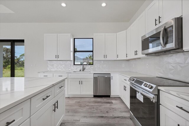 kitchen featuring white cabinets, light wood-type flooring, and appliances with stainless steel finishes