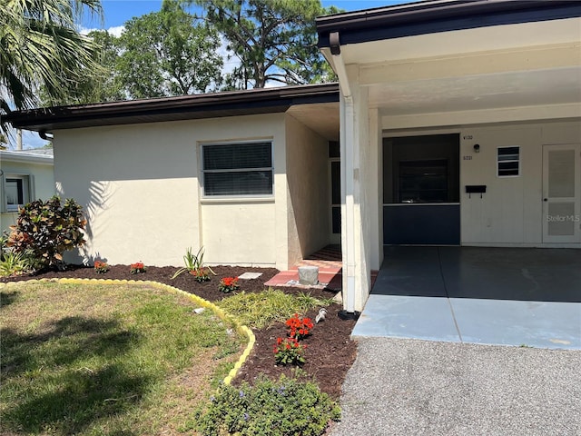 property entrance with a lawn