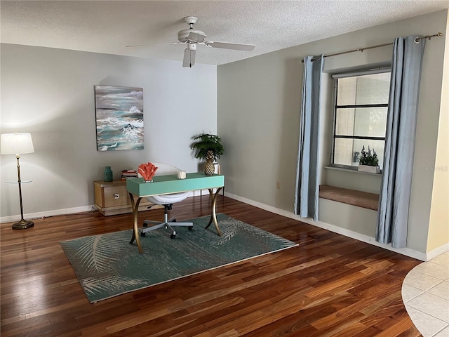 office area featuring ceiling fan, a textured ceiling, and dark wood-type flooring