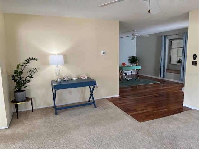 interior space featuring a textured ceiling, ceiling fan, and carpet floors