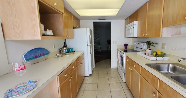 kitchen with sink, white appliances, and light tile floors