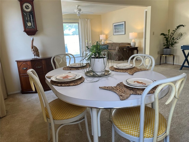 dining space with light colored carpet and ceiling fan