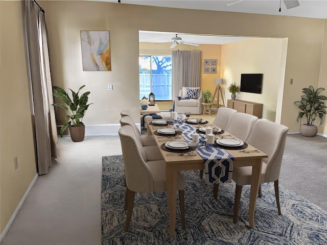 dining space with ceiling fan and carpet