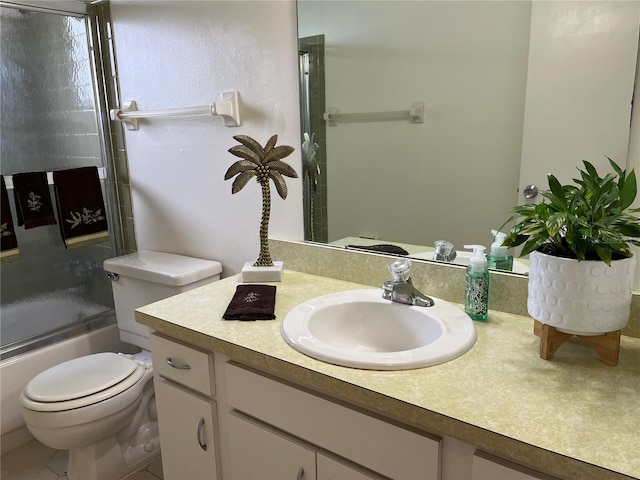 full bathroom with vanity with extensive cabinet space, tile floors, toilet, and shower / bath combination with glass door