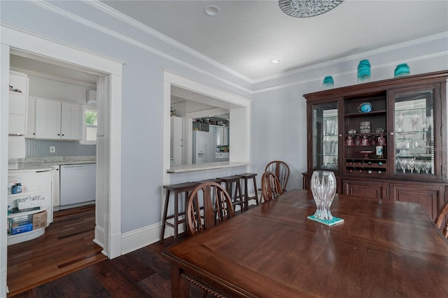 dining area with ornamental molding and dark hardwood / wood-style floors