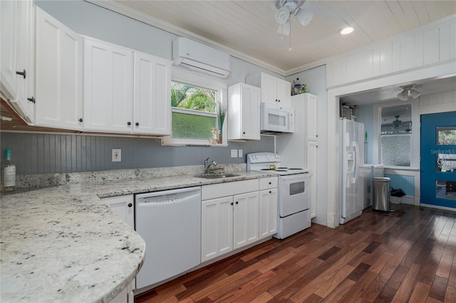 kitchen with white appliances, ceiling fan, white cabinetry, a wall mounted AC, and light stone counters