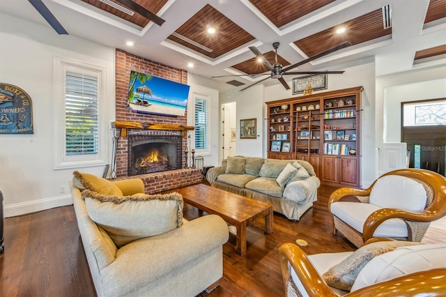 living room featuring coffered ceiling, dark hardwood / wood-style floors, ceiling fan, beamed ceiling, and a brick fireplace