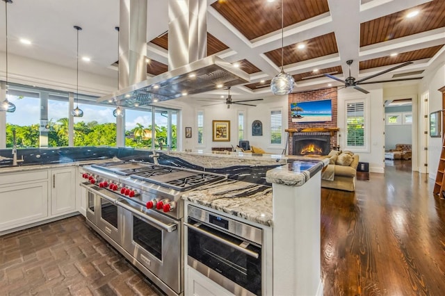 kitchen featuring white cabinets, plenty of natural light, pendant lighting, and a brick fireplace