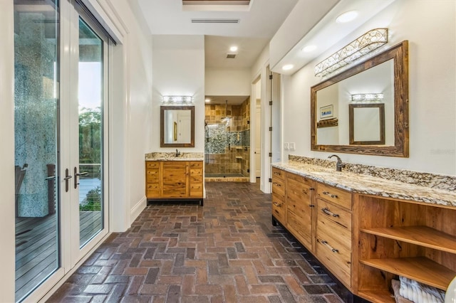 bathroom with french doors, dual vanity, and a shower with door