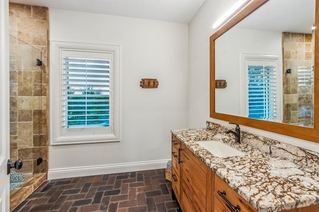 bathroom featuring a tile shower and large vanity