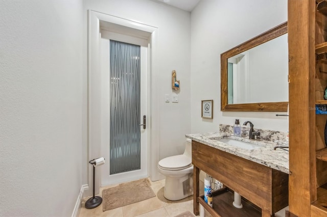 bathroom featuring vanity, tile flooring, and toilet