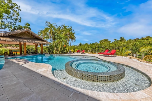 view of swimming pool with a patio area and an in ground hot tub