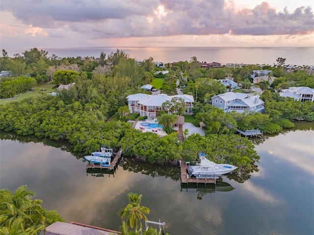 aerial view at dusk featuring a water view