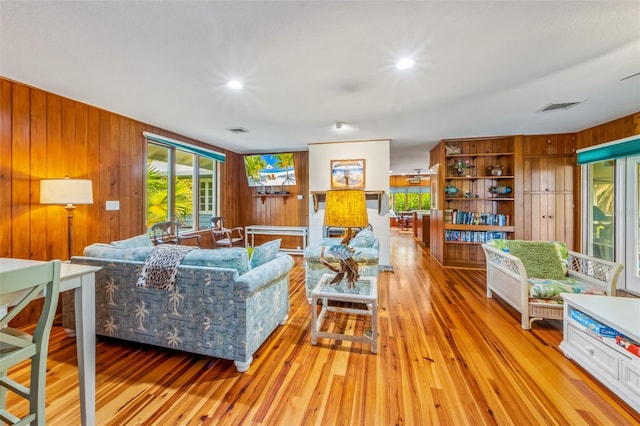 living room with wooden walls and light wood-type flooring