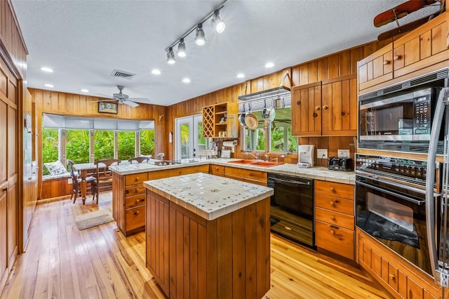 kitchen featuring a center island, plenty of natural light, ceiling fan, and black appliances