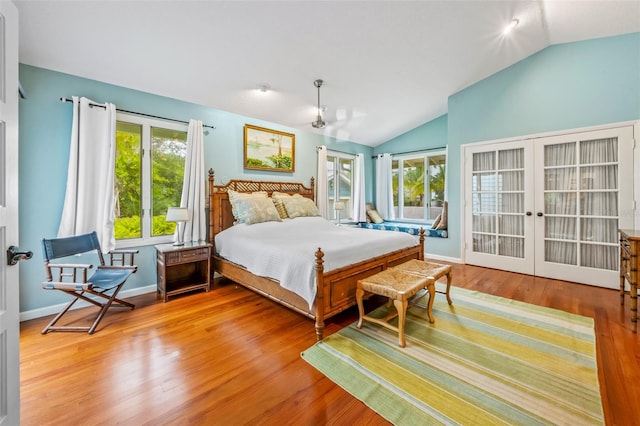 bedroom featuring vaulted ceiling, light wood-type flooring, and french doors