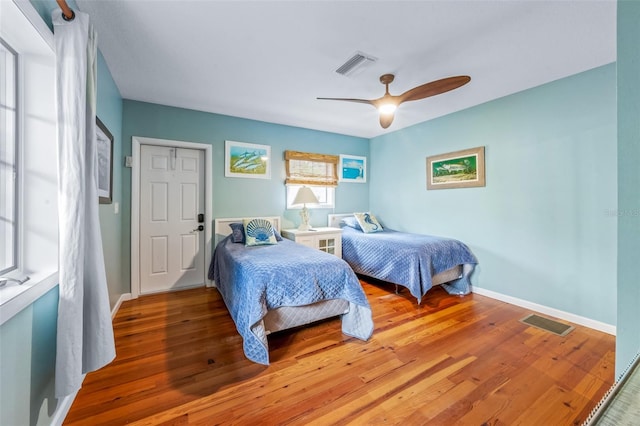 bedroom with a closet, wood-type flooring, and ceiling fan