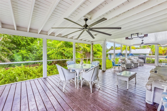 sunroom featuring ceiling fan and beam ceiling