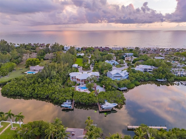 aerial view at dusk featuring a water view