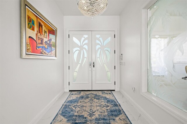 tiled entrance foyer featuring a chandelier and french doors