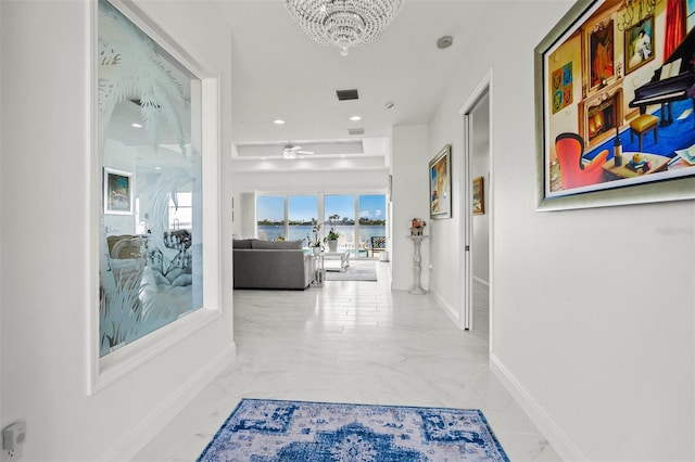 corridor featuring a chandelier and light tile floors