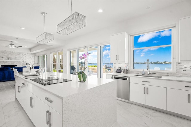 kitchen featuring light tile flooring, hanging light fixtures, a kitchen island, and white cabinetry