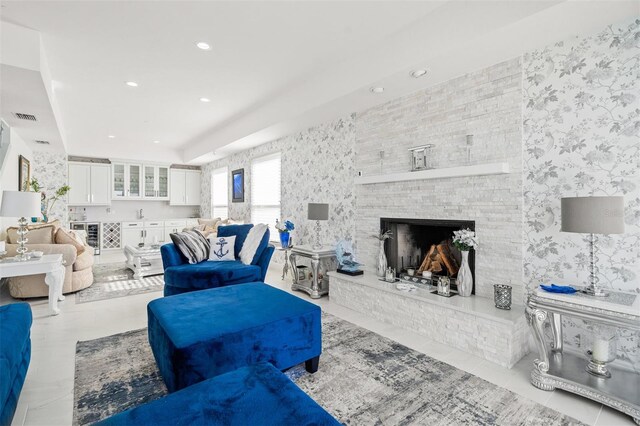 living room featuring tile walls, light tile floors, and a fireplace