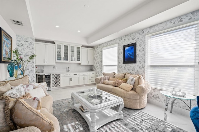 living room with plenty of natural light, sink, and wine cooler