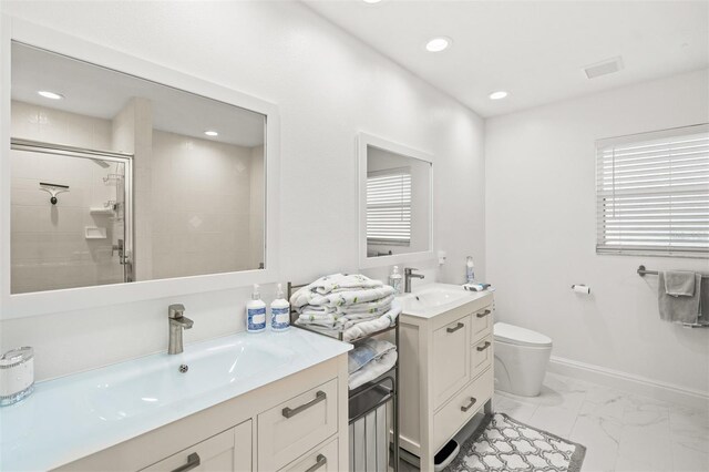 bathroom featuring double vanity, tile flooring, a shower with shower door, and toilet