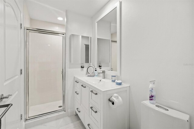 bathroom with tile floors, vanity with extensive cabinet space, and walk in shower