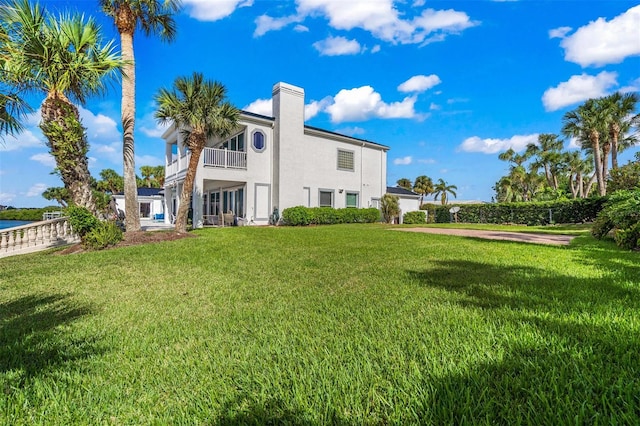 rear view of property featuring a lawn