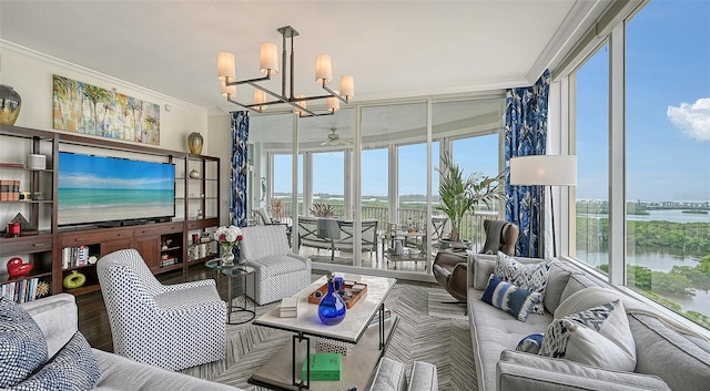 living room with a water view, ornamental molding, wood-type flooring, and ceiling fan with notable chandelier