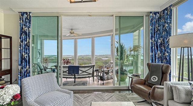 sunroom / solarium featuring a healthy amount of sunlight and ceiling fan