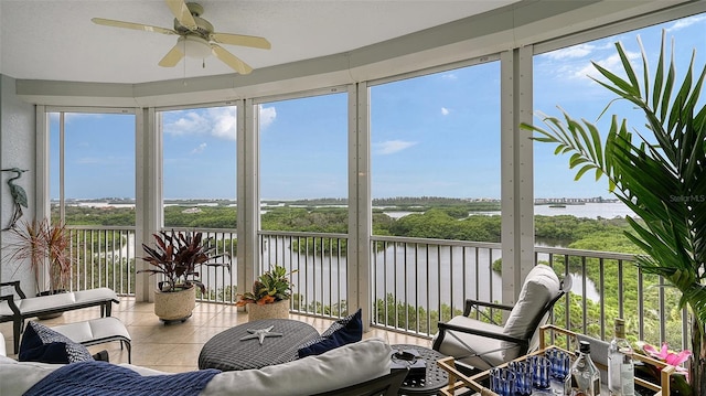 sunroom featuring a water view, ceiling fan, and a wealth of natural light