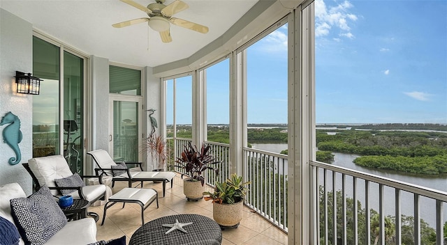 sunroom / solarium with a water view and ceiling fan