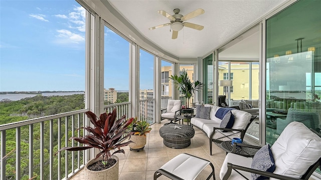 sunroom / solarium with a water view, ceiling fan, and a healthy amount of sunlight