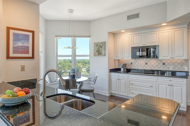 kitchen with black appliances, sink, dark hardwood / wood-style floors, and hanging light fixtures